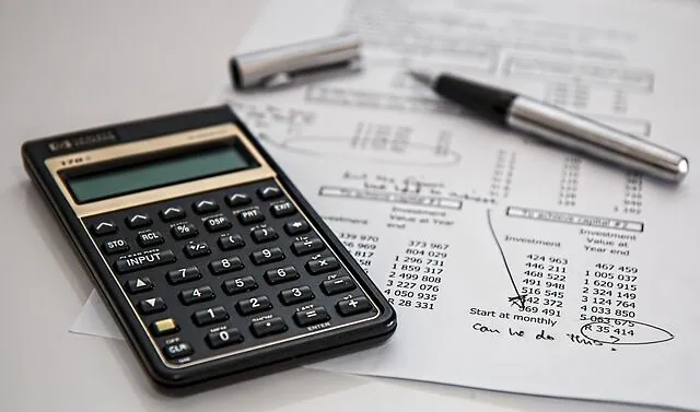 Calculator, pen, and financial documents.