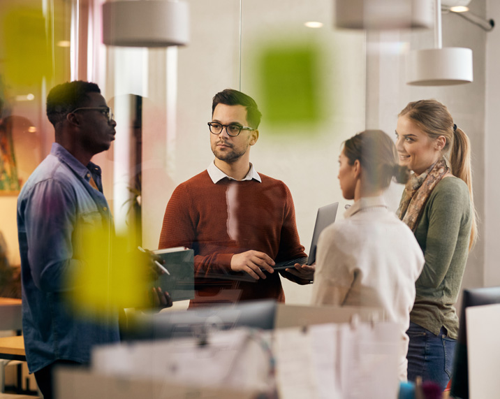 Four people discussing in an office.