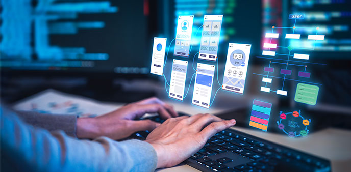 Hands on a keyboard with app design screens.